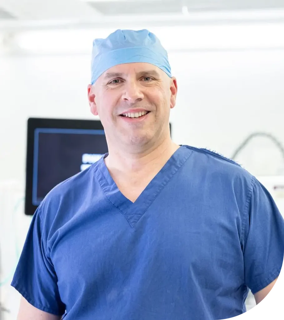 About Mr Marco Scarci – Consultant Thoracic Surgeon in London 2 Smiling medical professional in blue surgical scrubs and cap.