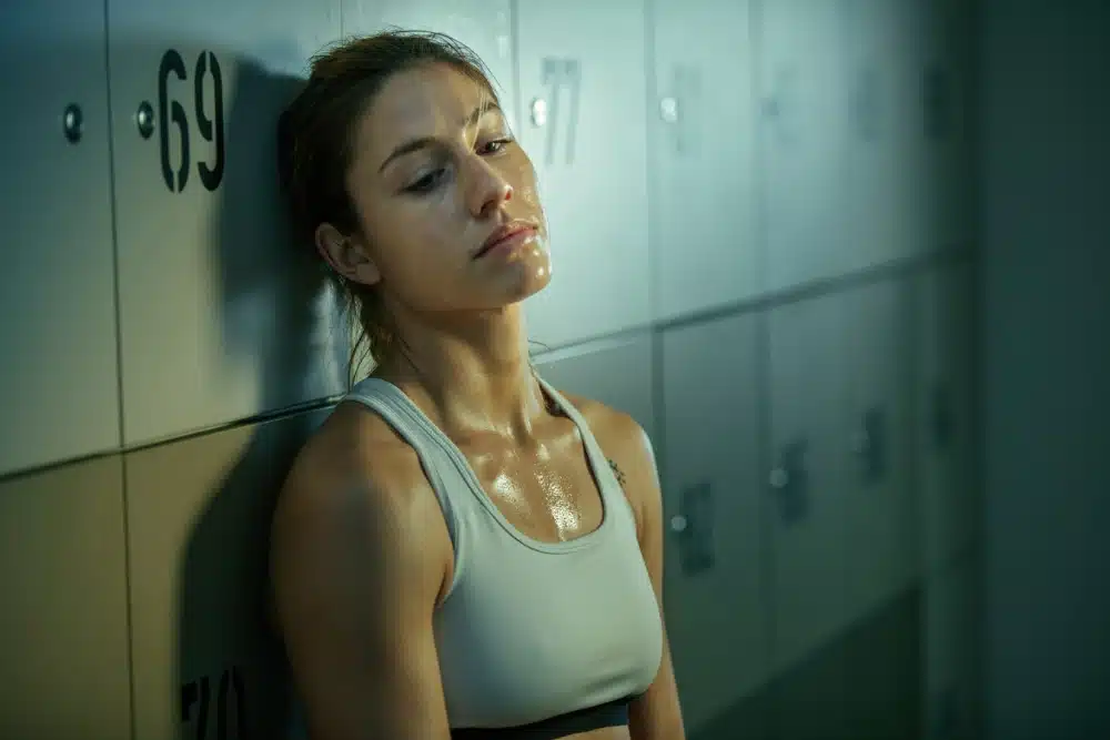 sweaty-sportswoman-feeling-tired-after-workout-relaxing-gym-s-dressing-room-thinking-something