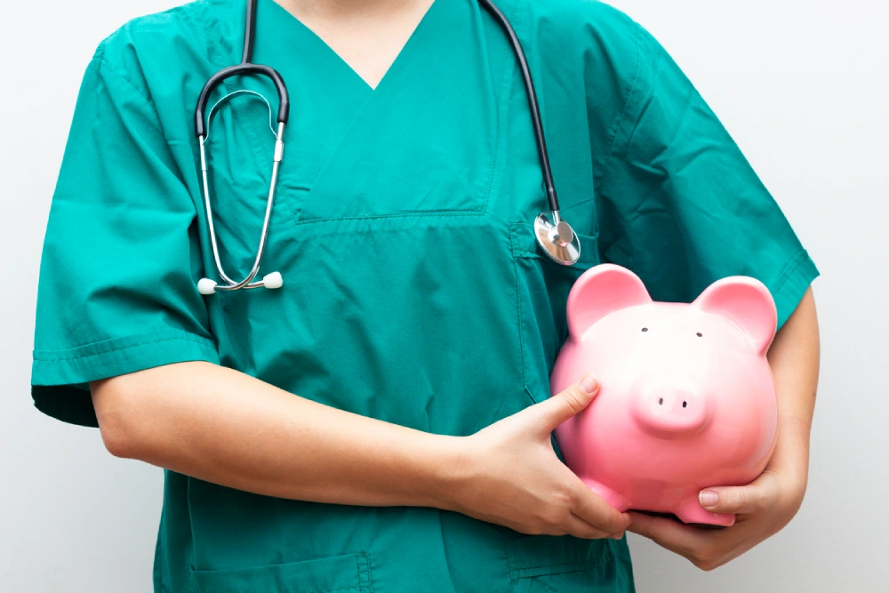 a nurse holding piggy bank