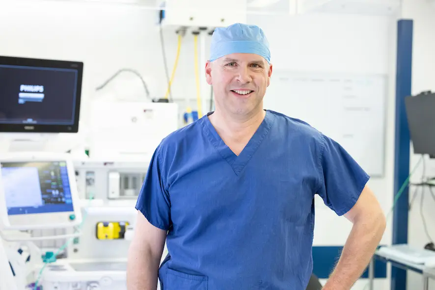 Mr Marco Scarci in the operating theatre, focused and preparing surgical instruments during a procedure, illustrating the real life of a thoracic surgeon at work.